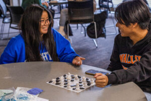 Two Creighton students play a game of Konane, a Hawaiian form of checkers, at the event.