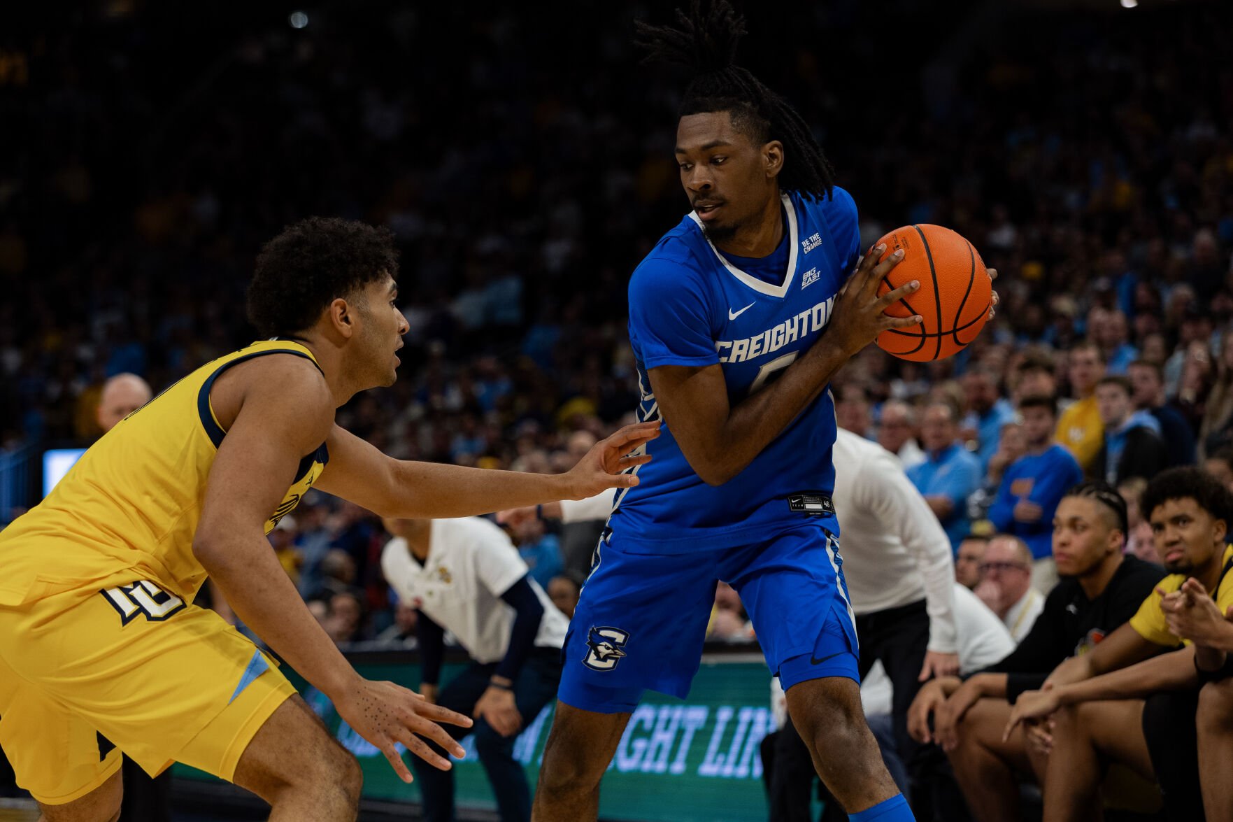 Senior Jamiya Neal holds the ball as a Marquette defender waits for him to make a move.