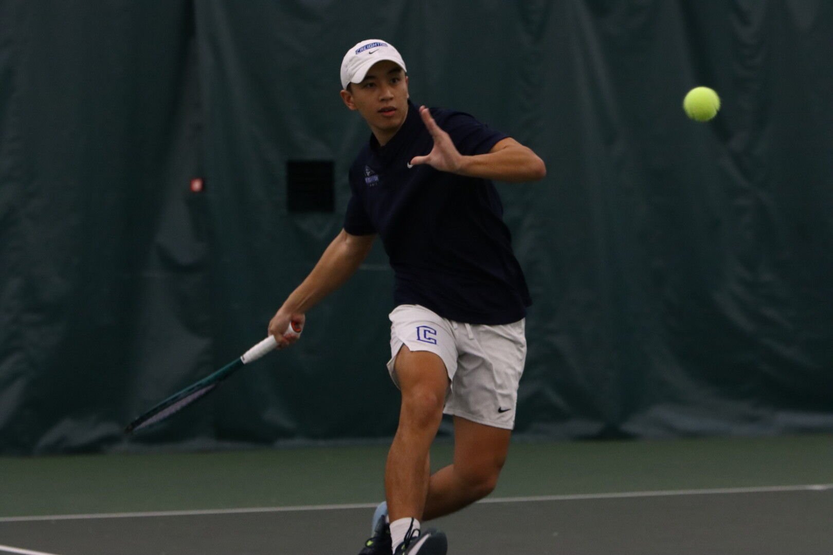 Junior Zachary Kuo lines up to hit a forehand in the Bluejays' home matchup. The team played Pratt Community College and Midland University.