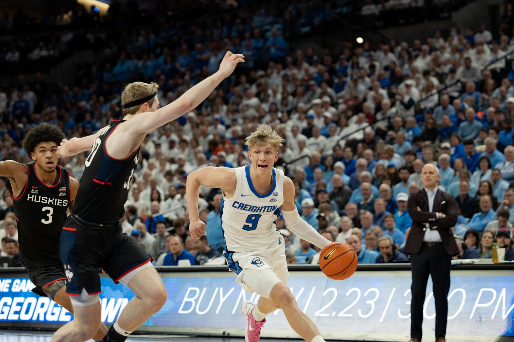 Freshman Ty Davis drives toward the basket as UConn freshman Liam McNeeley trailing him.