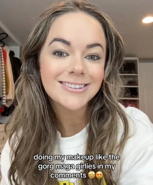 Image of a woman with makeup, smiling, with the TikTok caption "doing my makeup like the gorg maga girlies in my comments."