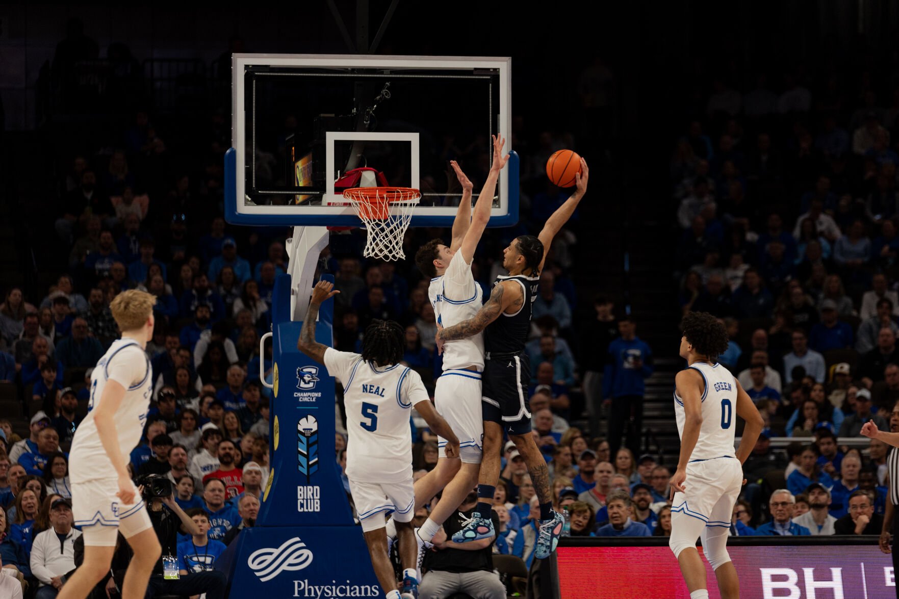 Senior Ryan Kalkbrenner jumps into the air with his arms raised straight up to challenge an incoming dunk from the Georgetown offense.