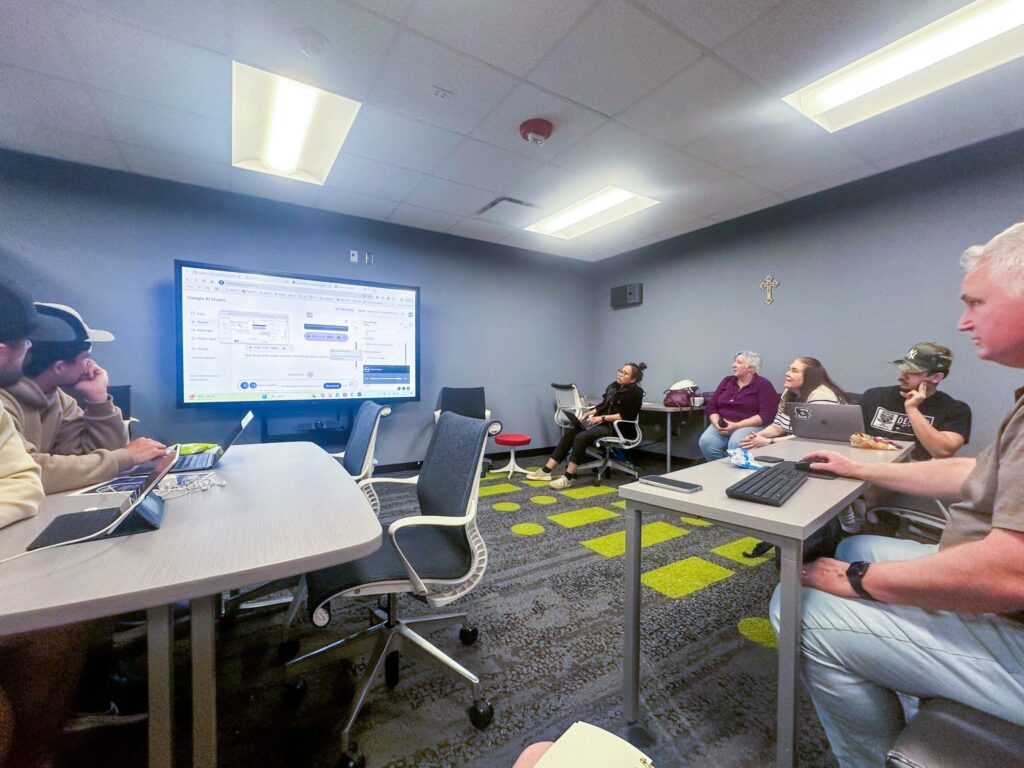 People sit in a room while someone presents.