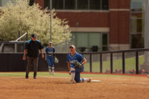Sophomore first baseman Sydney Potter yells in excitement following a mid-air throw from sophomore shortstop Ashten Pierson for the out.