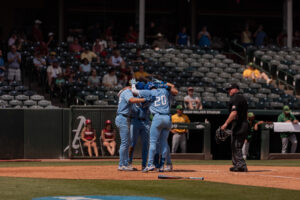 The Jays come together at home plate after a three-run homer from graduate student Kyle Hess.