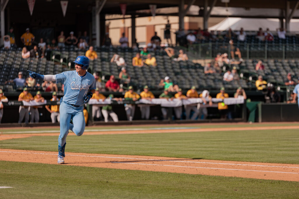 Kyle Hess smiles at the Creighton dugout after hitting single over the first baseman's head to bring the go-ahead run home in the game against NDSU.