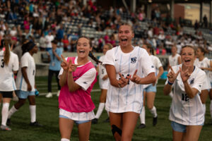 Juniors Clara Kulick and Mallory Connealy hold up 'W's in celebration after defeating UNO 3-2.