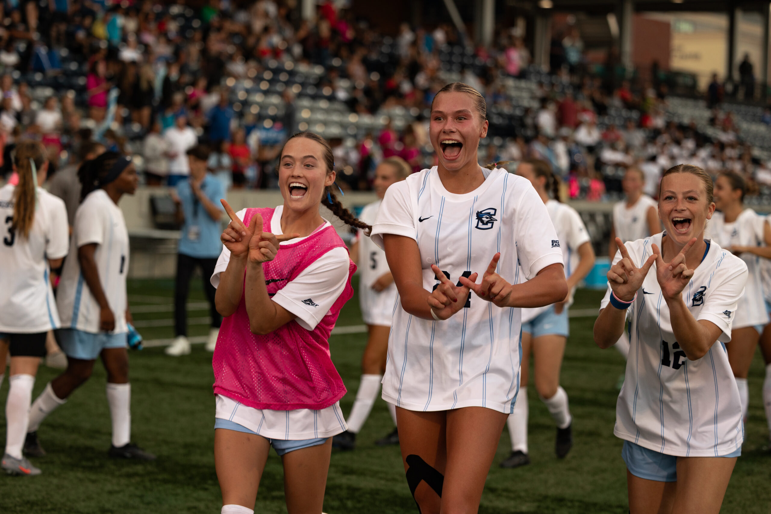 Juniors Clara Kulick and Mallory Connealy hold up 'W's in celebration after defeating UNO 3-2.